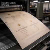 Impression offset d'étiquettes de champagne sur papier martelé ivoire Creative Labels Martelé – rendu texturé haut de gamme en cours d'impression, adapté aux étiquettes vin , Antalis France