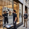Poseur appliquant un logo en vinyle miroir argenté 3M Scotchcal 8855 Mirror sur la vitrine d'une boutique sous la supervision d'un responsable