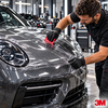 Technicien appliquant à la raclette le film de protection carrosserie transparent 3M Scotchgard Pro Series 200 sur le capot d'une voiture de luxe