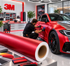 Poseur appliquant un film de covering rouge satiné 3M Wrap Film Série 2080 sur un véhicule