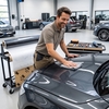 Technicien appliquant un film coulé 3M Wrap Film Série 2080 gris foncé sur le capot d'une voiture