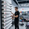 Poseur sélectionnant un rouleau de film de protection carrosserie Avery Dennison SPF sur rack de stockage