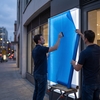 Deux techniciens poseurs appliquant le film translucide Avery Dennison 4500 TF sur une enseigne lumineuse de magasin