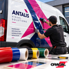 Poseur appliquant un vinyle adhésif polymère ORACAL 551 sur un fourgon utilitaire devant des rouleaux de couleurs