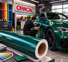 Poseur marouflant un film de covering vert métallisé ORACAL 970RA sur une portière de voiture