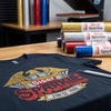 T-shirt noir floqué d'un logo aigle avec typographie Siser Sparkle réalisée en flex pailleté rouge, or, argent et bleu