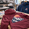 Vestes de randonnée bordeaux et bleue floquées d'un motif montagne en flex imprimable POLI-TAPE TURBO PRINT 4010-S BLOCKOUT sur table d'atelier